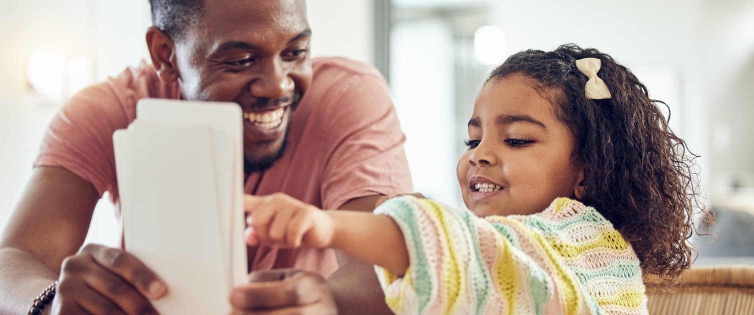 Image shows a dad showing flash cards to a child