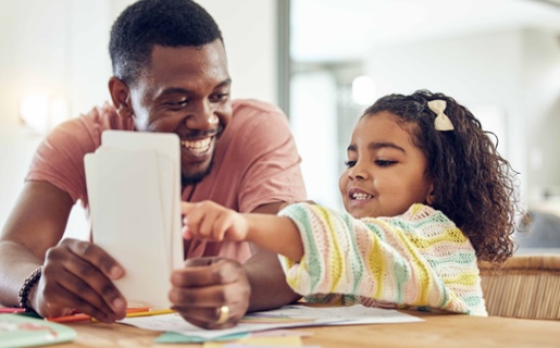 Image shows a dad showing flash cards to a child