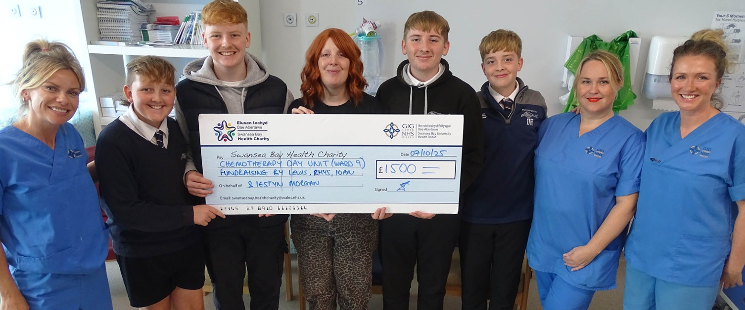 Image shows a family and nurses at a cheque presentation.