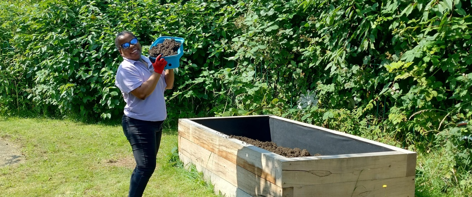 Image shows a woman holding soil