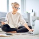 An image of a woman sitting on the floor working from home