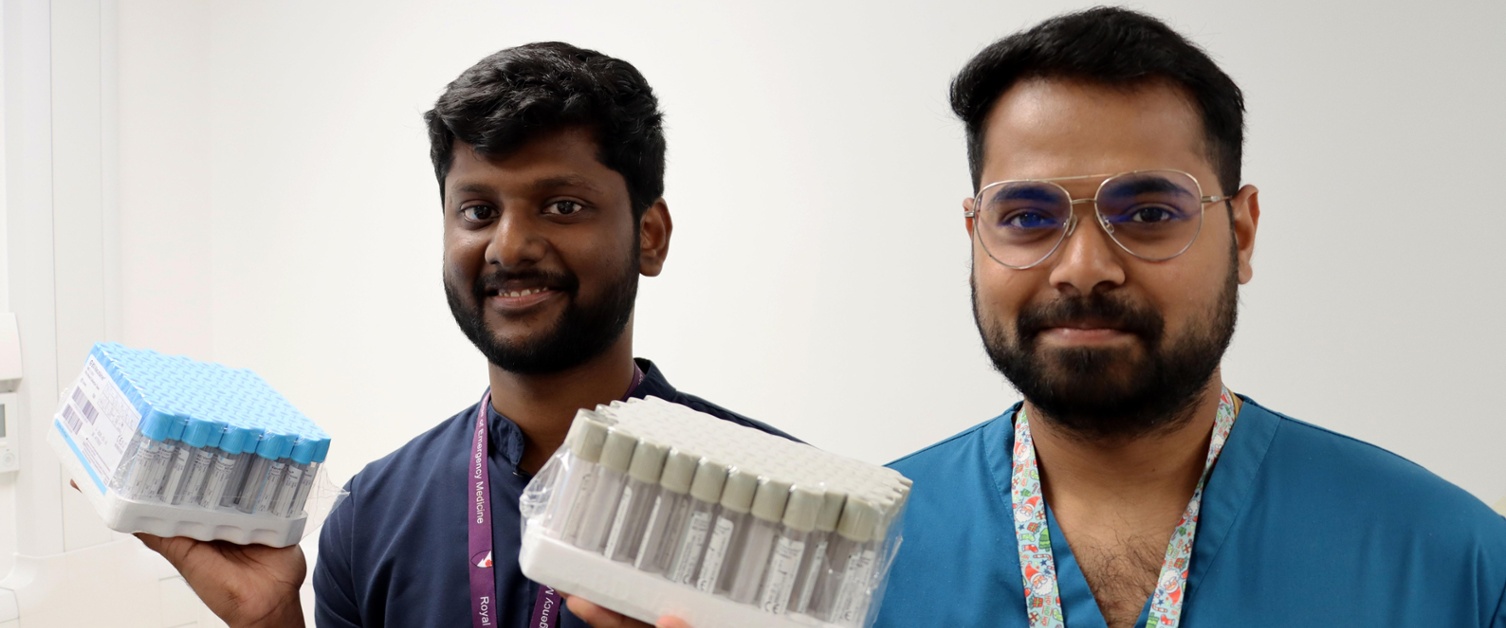 Image shows two men holding bottles