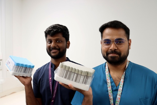 Image shows two men holding bottles