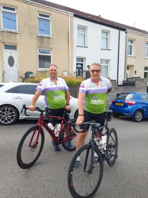 Image shows two men sitting on bicycles