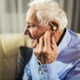 Image shows man with a hearing aid in their ear.