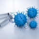 Two syringes on a table next to three blue COVID viruses.