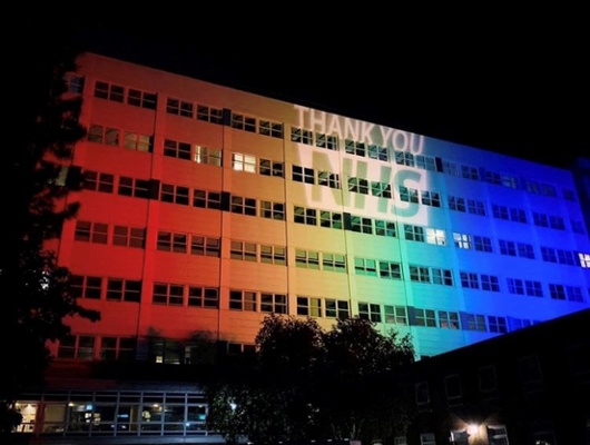 Image shows a building lit in rainbow colours
