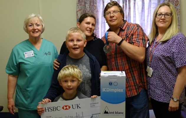 Nursery Nurse Gillian Thomas and receptionist Dawn Jenkins receive the cheque from the family.