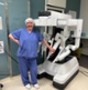 Image shows a woman stood next to a medical machine