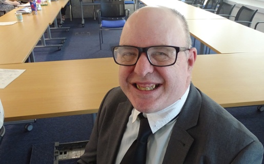 Image is of a smiling man looking into the camera.