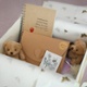 A small box containing a notebook, an envelope and two cuddly toys