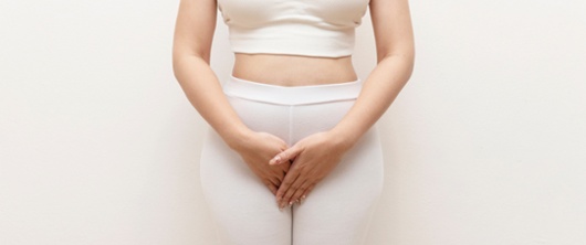 A woman holding her pelvic area