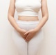 A woman holding her pelvic area