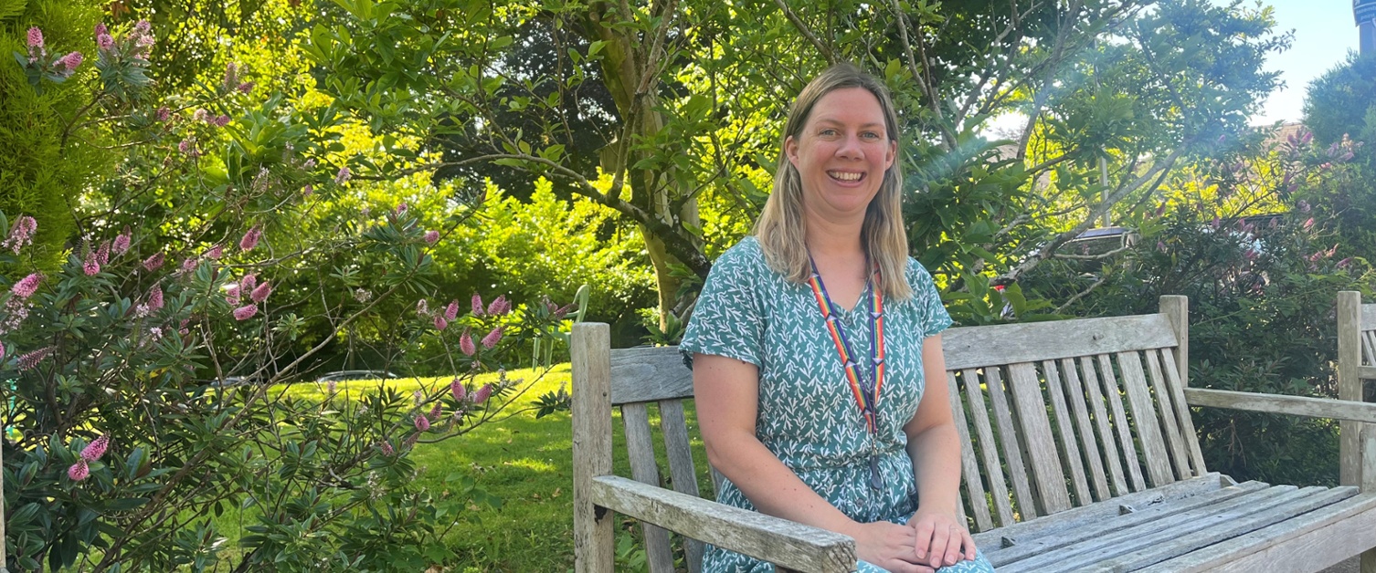 Image shows a woman sat on a bench