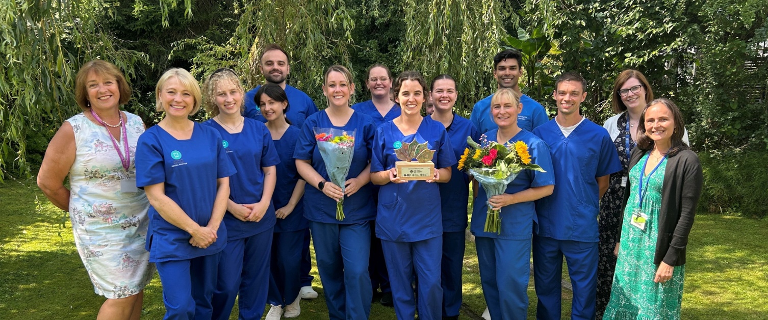 Dental staff with health board staff in a garden area
