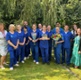 Dental staff with health board staff in a garden area