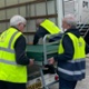 Workmen loading up beds onto a van.