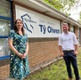 Image shows a woman and man standing in front of a sign