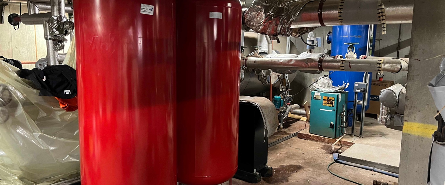 Image of two large brown tanks in the middle of the plant room.