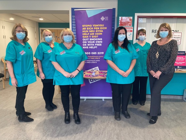 A group of women wearing scrubs standing in a hospital reception