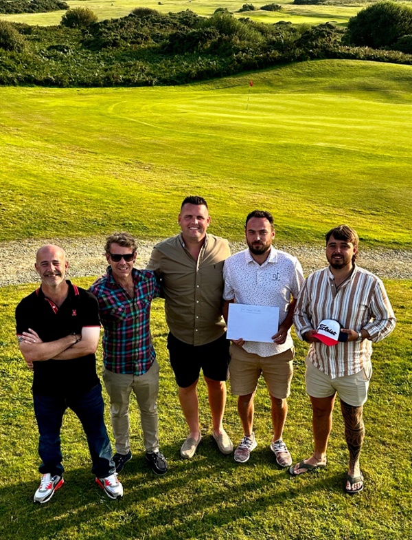 A group of golfers, standing in the sunshine on a golf course.