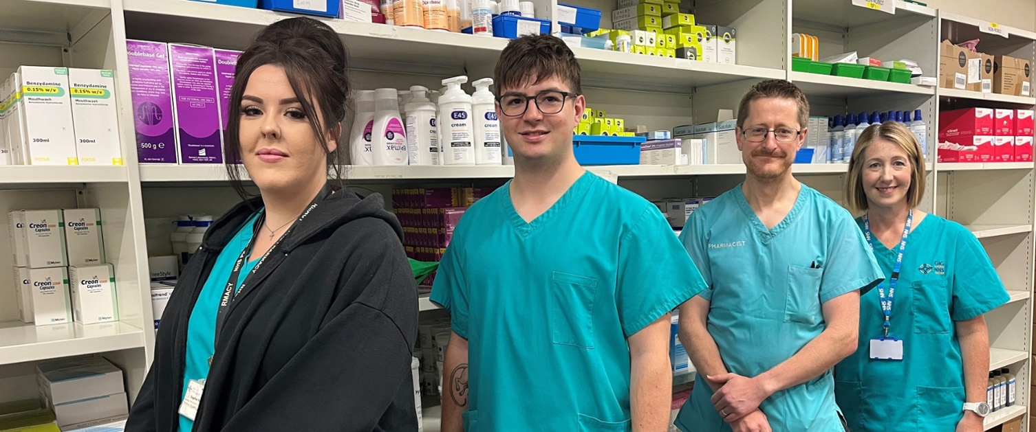 Image shows medical staff standing in front of a medication cabinet