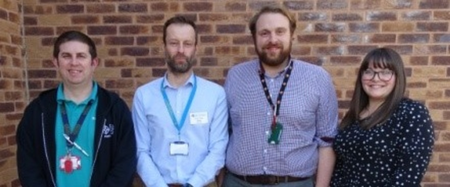 A team of pharmacists smiling at the camera.