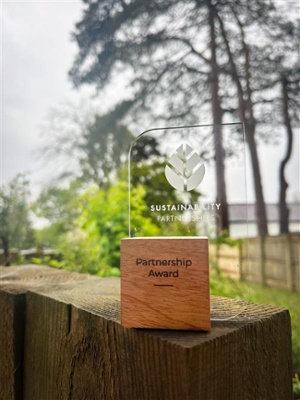 Image shows an award in front of a tree
