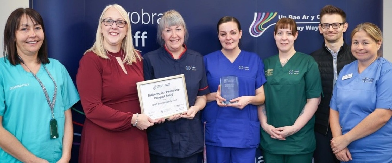 A nurse receiving an award from a smiling woman