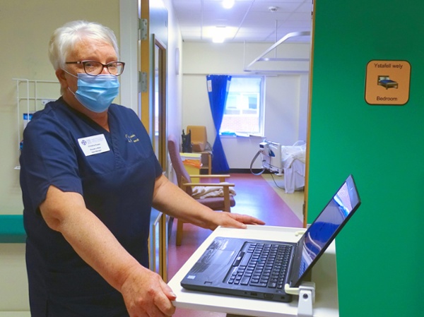 Nurse in a hospital ward using a laptop