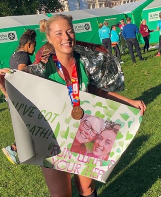 A London Marathon runner celebrating completing the course