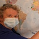 Andrea pictured with mask on places a pin in the map.