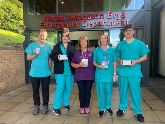 Image show a group of medical staff standing outside an emergency department reception