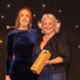 Image shows two women and an award