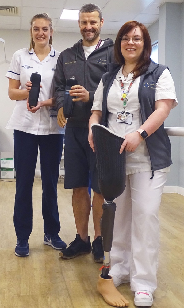 Image shows three hospital staff holding artificial leg appliances