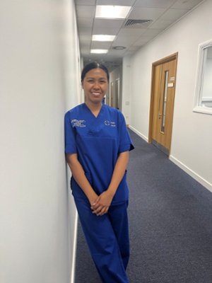 Image shows a woman standing in a corridor