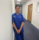 Image shows a woman standing in a corridor