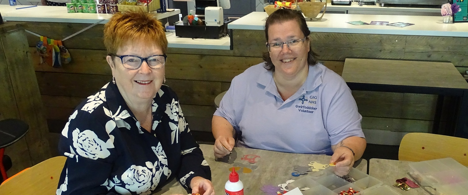 Image shows two people at a cafe table.