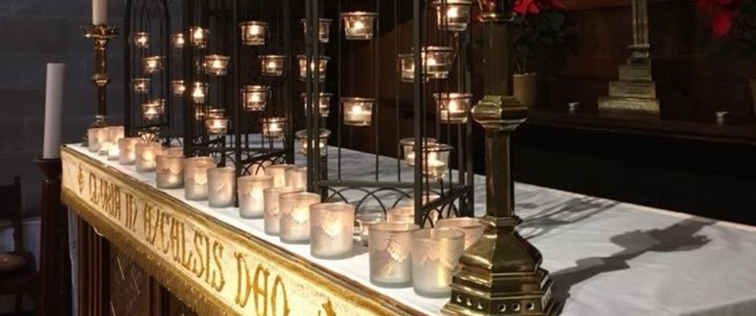 A table set up of candles in a church.