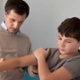 Image shows a doctor examining the arm of a young boy.