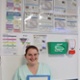 A member of hospital catering staff standing in front of a notice board covered in information about dysphagia