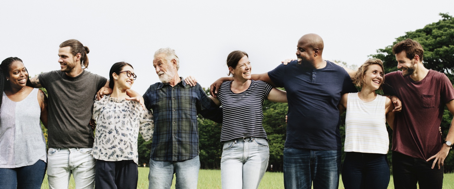 Men and women in line looking happy with arms around each other.