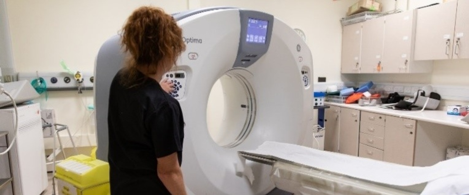 An image of a woman standing next to an MRI scanner