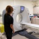 An image of a woman standing next to an MRI scanner