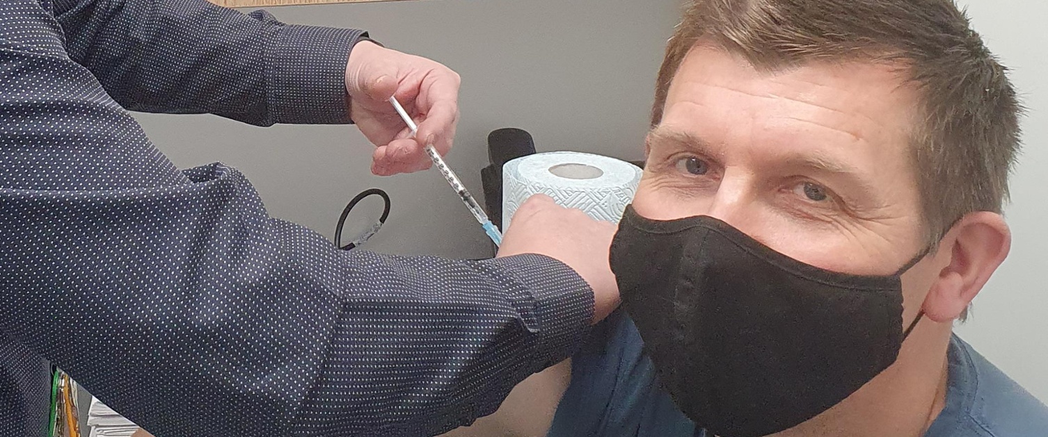 Image shows a patient receiving his flu vaccination