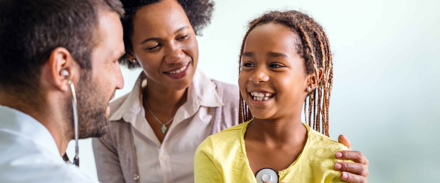 Image shows a doctor listening to a child