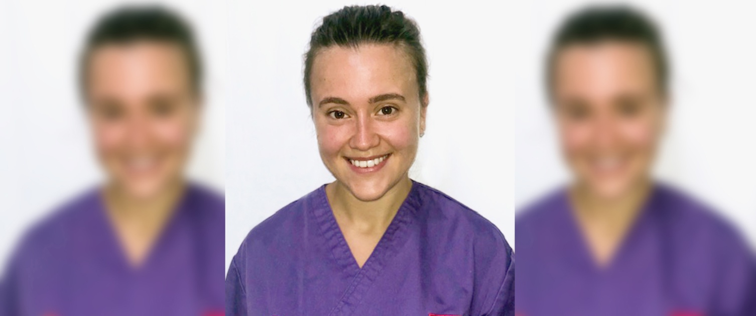 Image of student nurse Megan Ware smiling at camera in purple scrubs