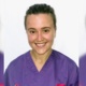 Image of student nurse Megan Ware smiling at camera in purple scrubs