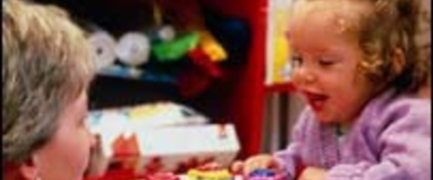 A young girl playing with her mother