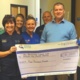 Former patient Ian Horsley gives a cheque to staff at the Welsh Centre for Burns and Plastic Surgery, Morriston Hospital.
